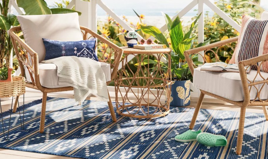 wicker chairs with white cushions and matching side table