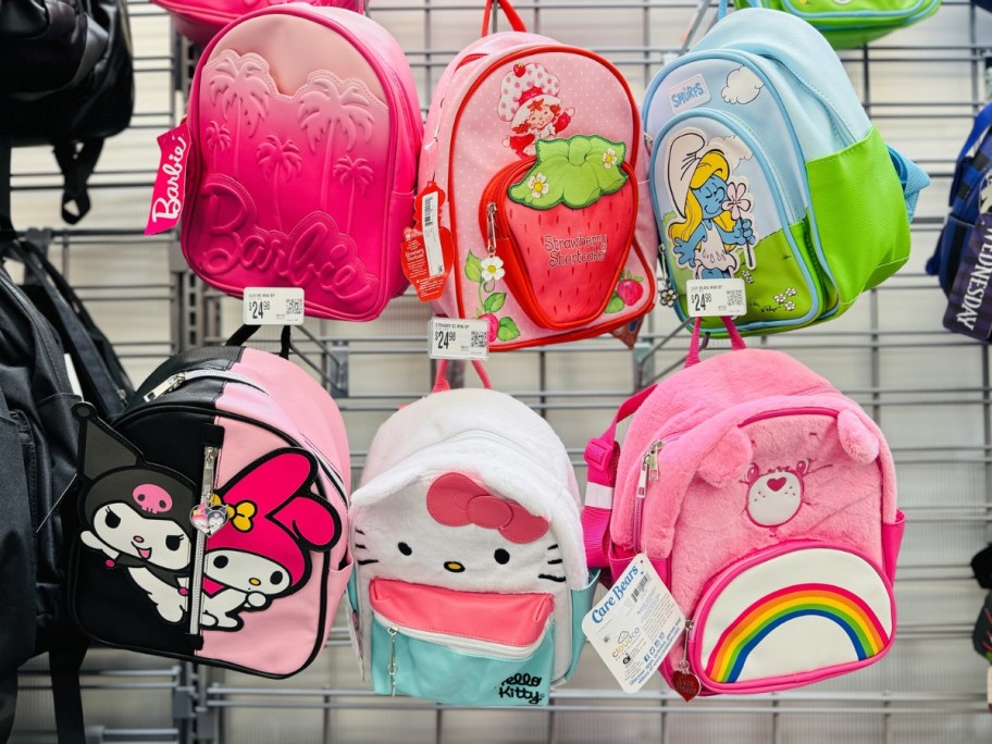 mini character backpacks with barbie, strawberry shortcake, care bears, hello kitty, and smurfs designs