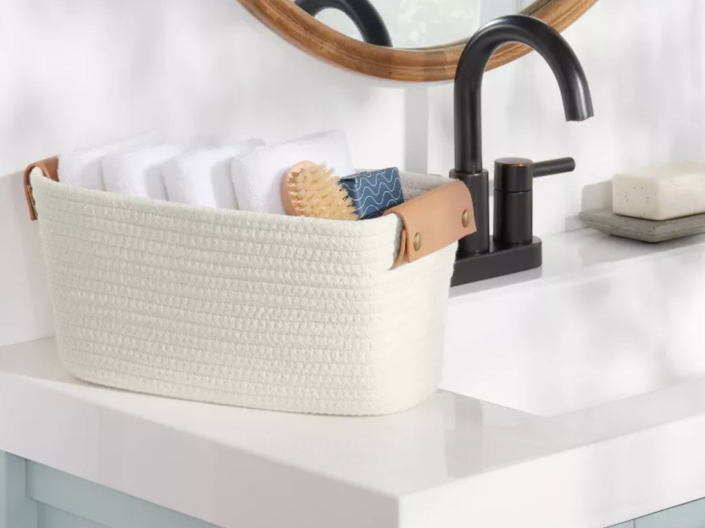 White coiled basket with brown leather handles on kitchen countertop