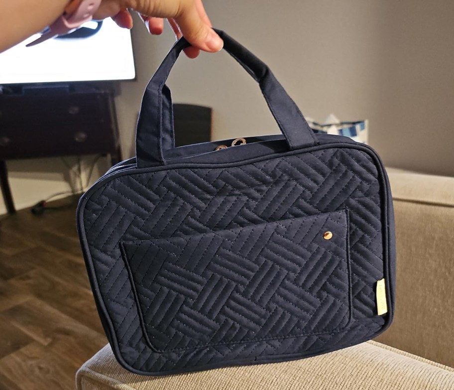 person holding toiletry travel bag