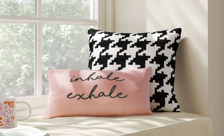 a black and white houndstooth pillow on a window seat