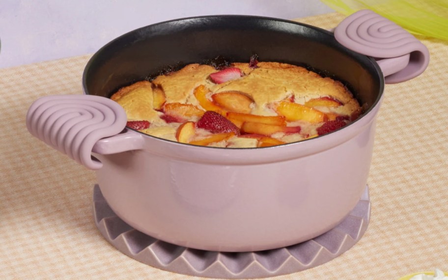 lilac dutch oven with fruit bread in it