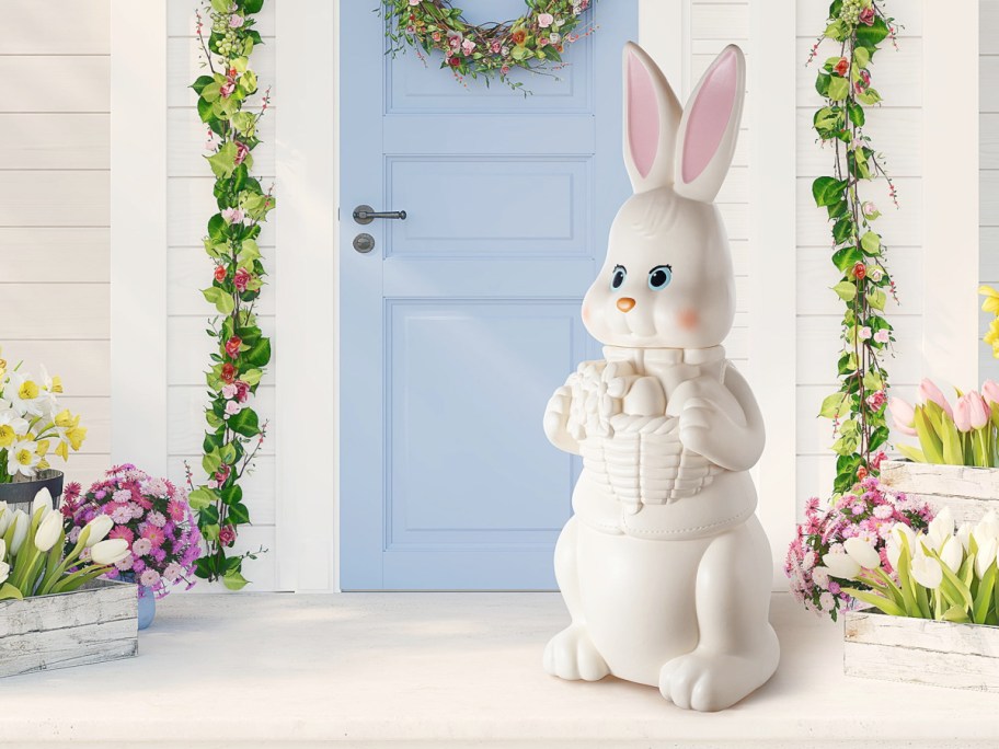 easter bunny blow mold in front of a blue door and floral garland and arrangements