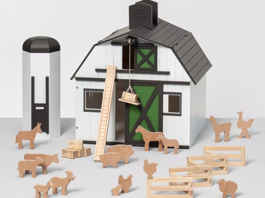 a wooden toy black and white barn with silo and farm animals