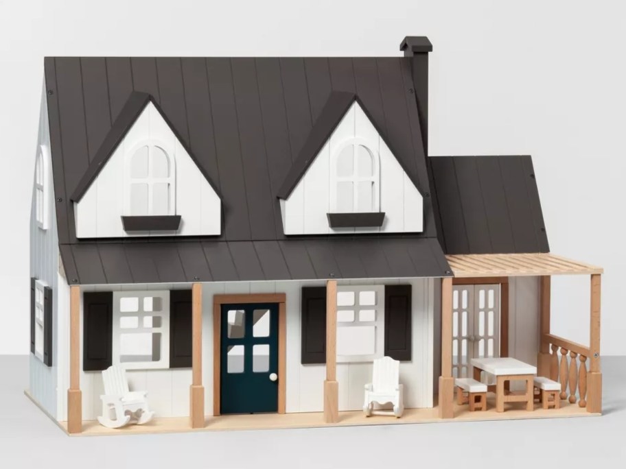 a wooden toy dollhouse that looks like a farm house