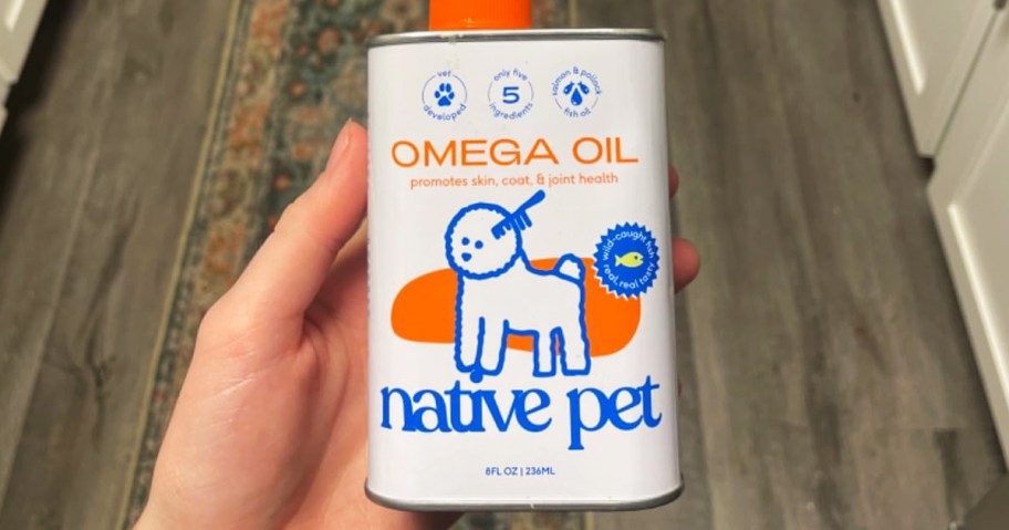 hand holding a tin of omega oil for pets