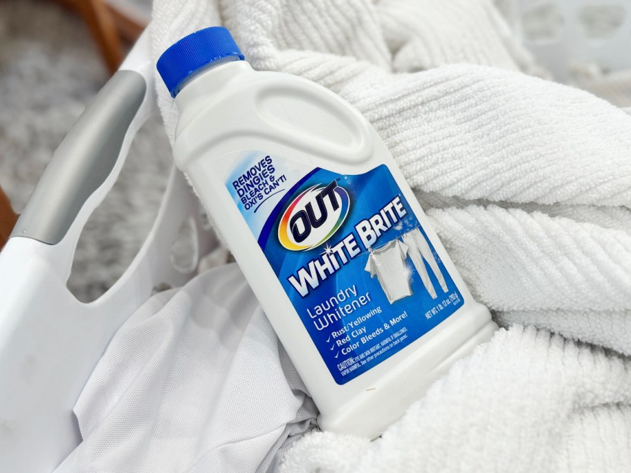 bottle of out white brite laying on white towels