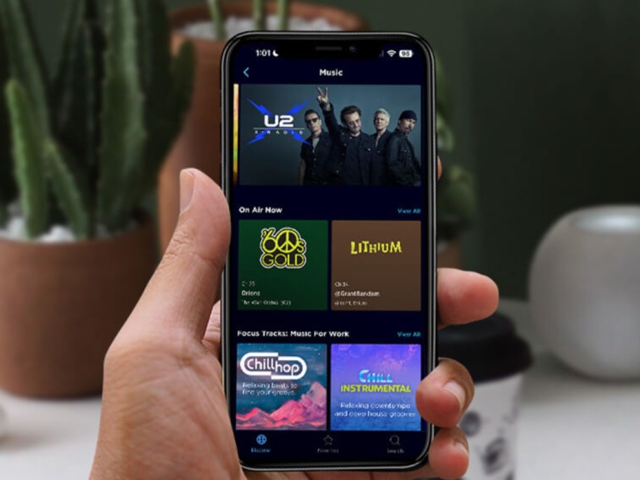 hand holding an iphone with the Sirius XM app open on it