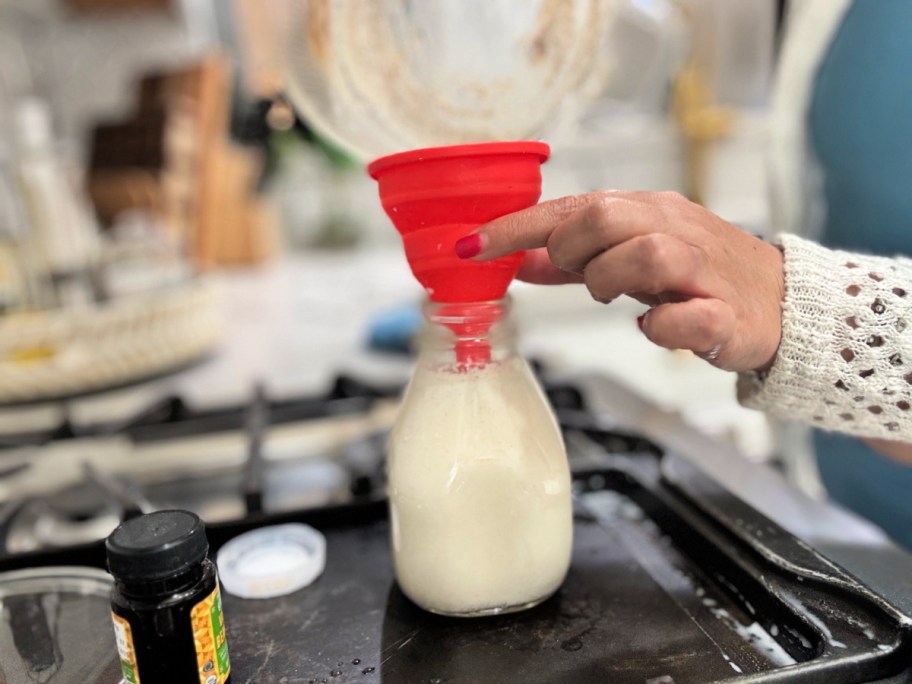 using a funnel to pour homemade coffee creamer