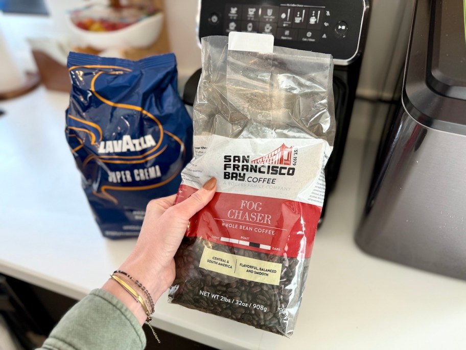 two bags of whole bean coffee next to coffee maker