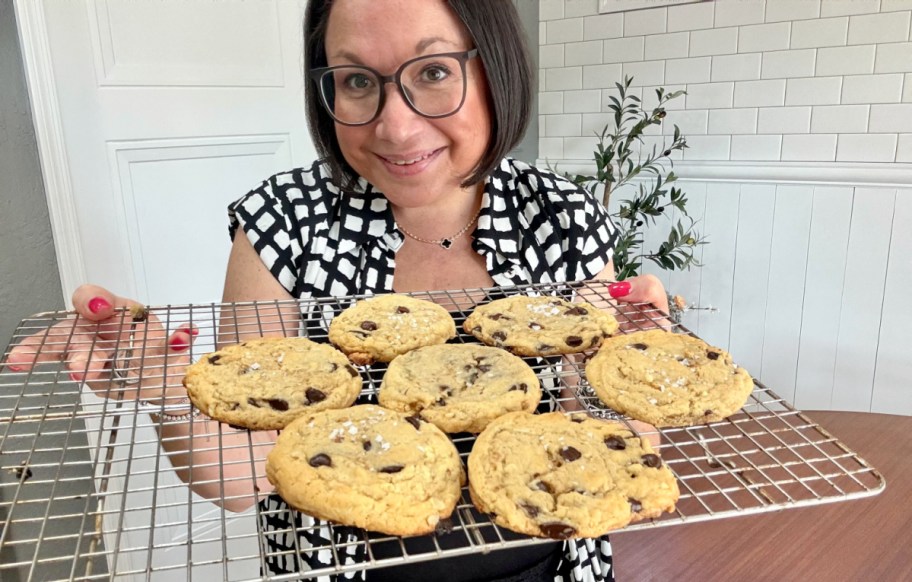 woman holding sourdough cookies on a cooling rack (