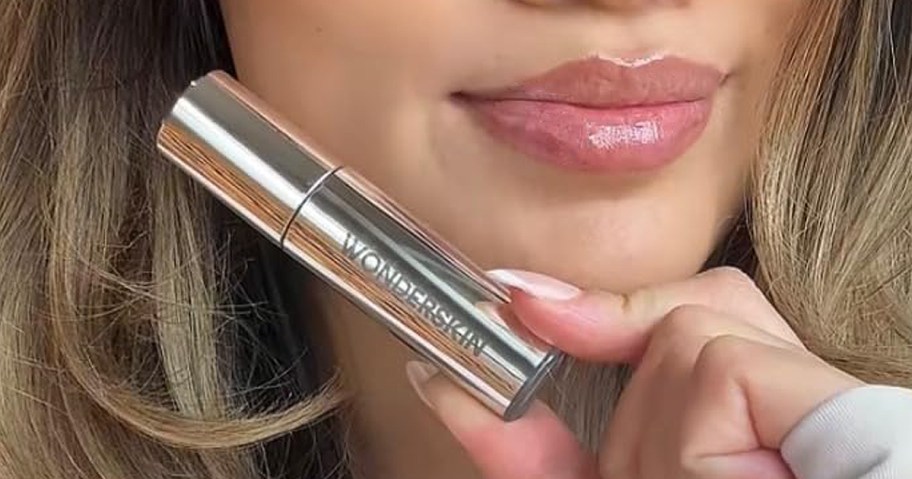 woman holding a tube of wonderskin lip oil