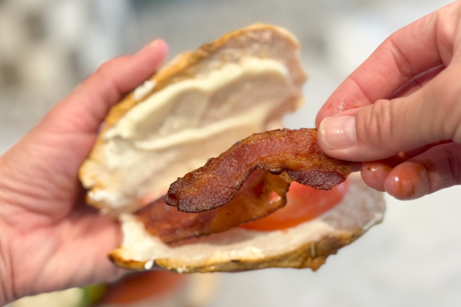 hands putting bacon on chicken breast BLT