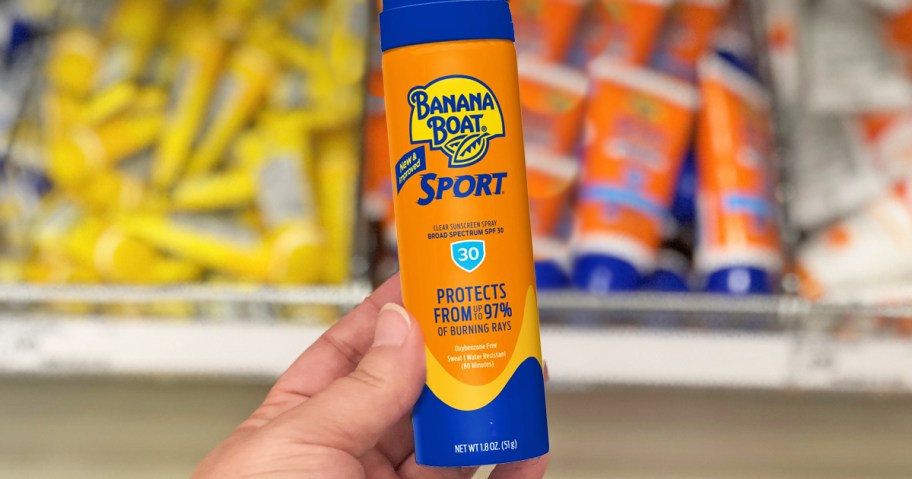hand holding a small bottle of Banana Boat sunscreen spray