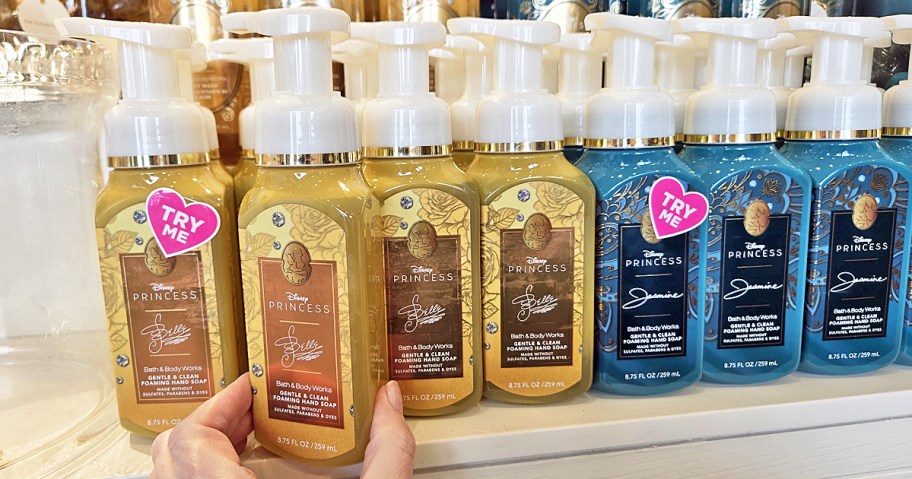 hand touching a display of disney princess themed hand soaps
