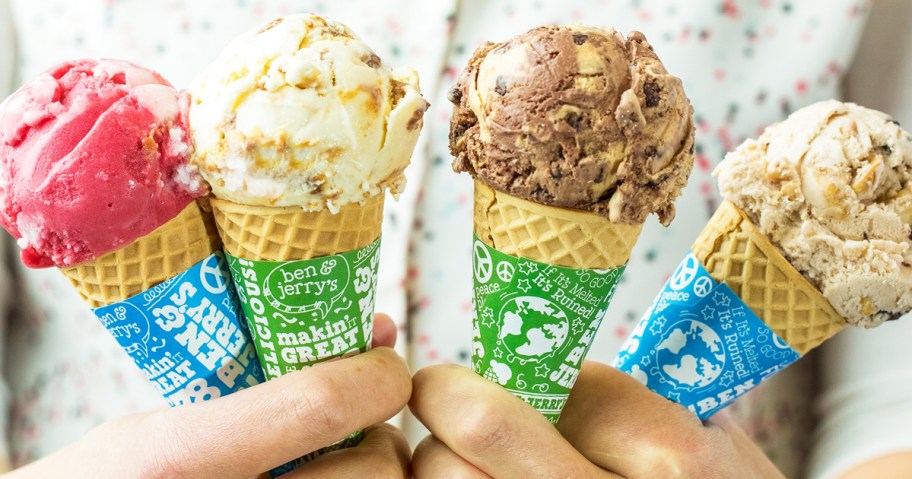 two hands holding four ice cream cones
