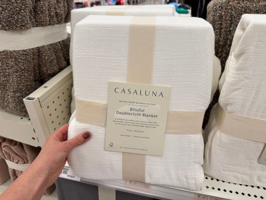 A person holding a white blanket in a store