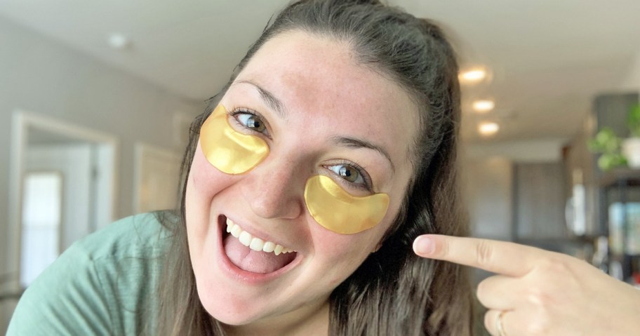 woman pointing to the gold under eye patches on her face