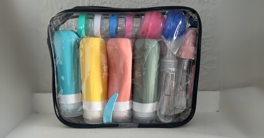 a clear and black zipper cosmetic bag with colorful travel size bottles and containers inside