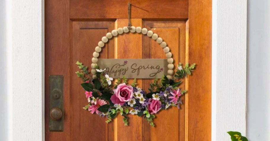 a beaded and floral spring wreath on a wooden door