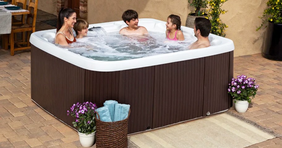 woman and kids sitting in hot tub with jets on