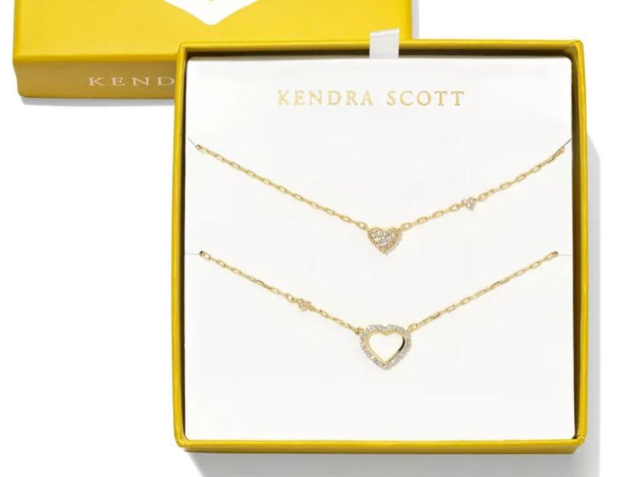A gold box with 2 necklaces in it 