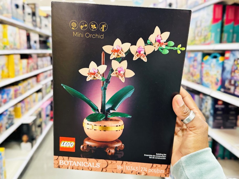 hand holding up box for LEGO Mini Orchid set in store