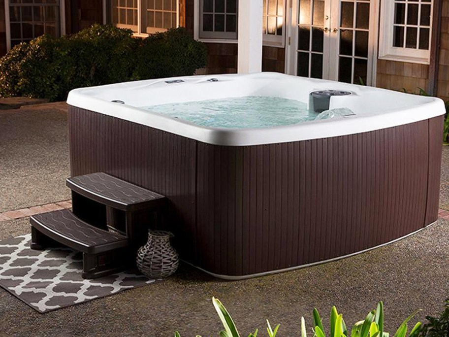 brown square hot tub with stairs in backyard