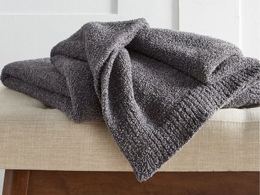 Hotel Collection 50" x 70" Luxe Knit Throw on an ottoman