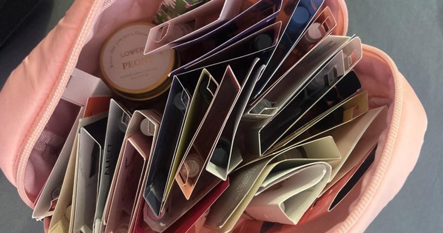 A pink cosmetics pouch with 26 Macy's Favorite Scents for Women inside