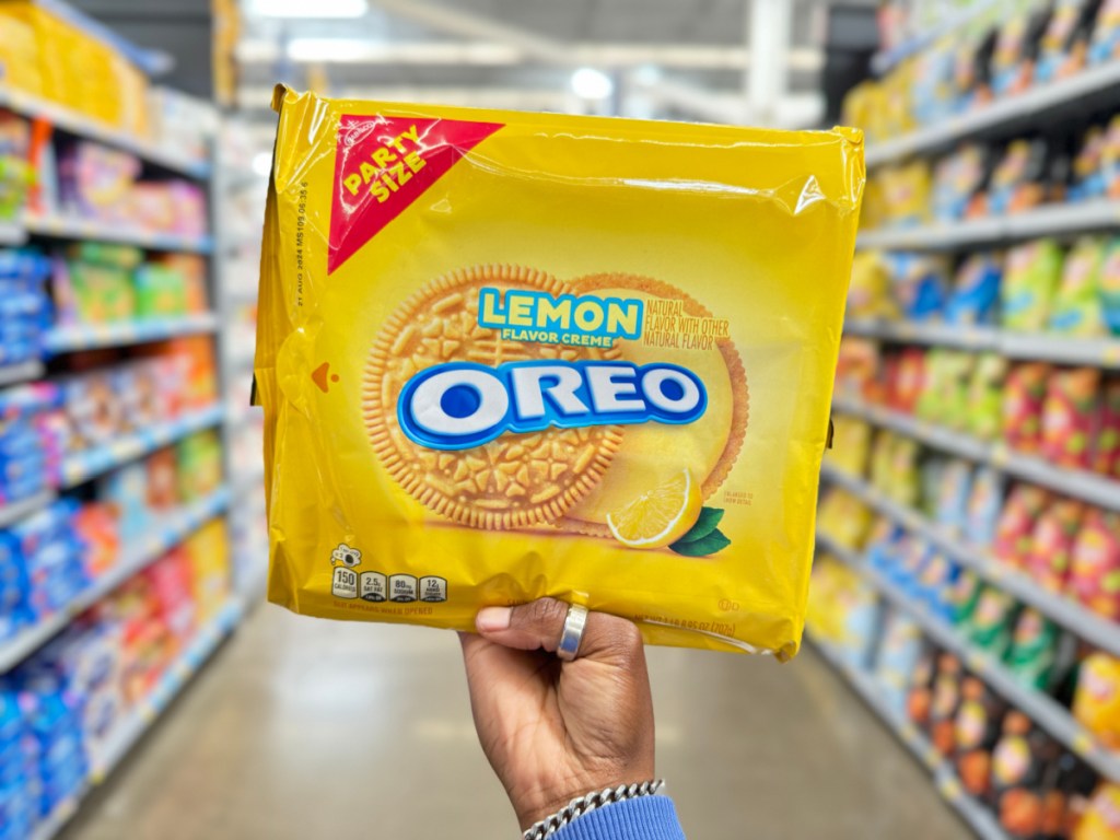 Person holding up yellow Oreo, lemon party size package in store aisle