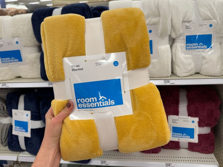 A person holding a yellow blanket in a store