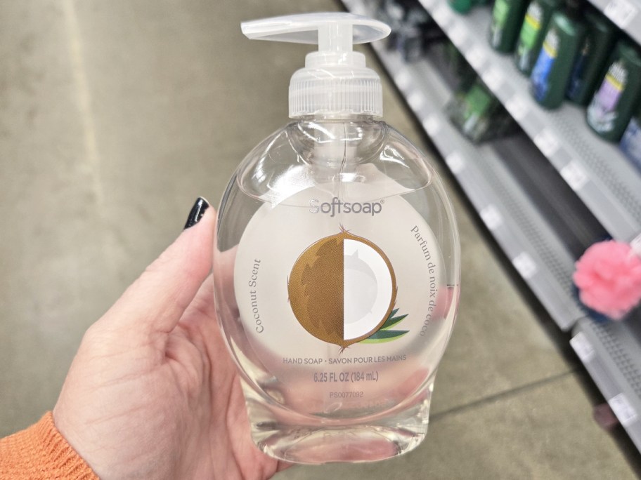 hand holding up a clear bottle of Softsoap coconut hand soap in store