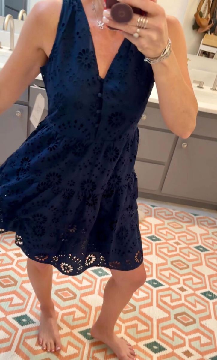 woman wearing navy blue eyelet dress in mirror