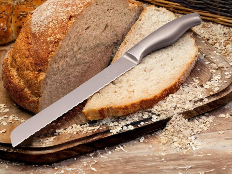 a metal serrated bread knife with a loaf of bread