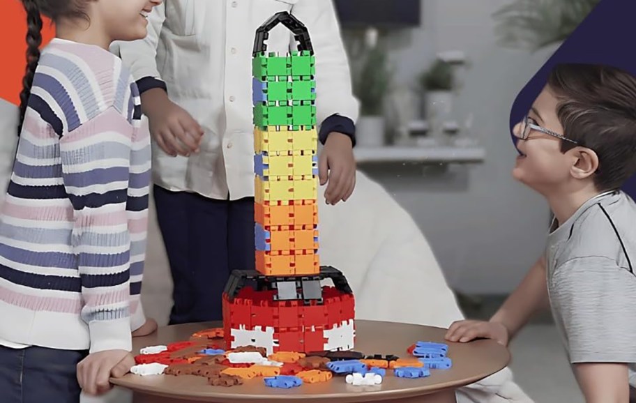 kides with block set constructed into a rocket on a table