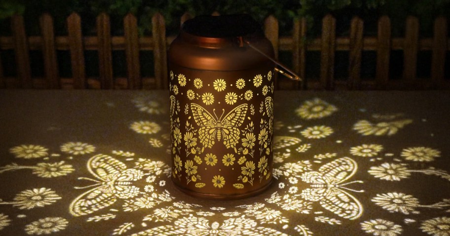 butterfly solar lantern sitting on a patio at night