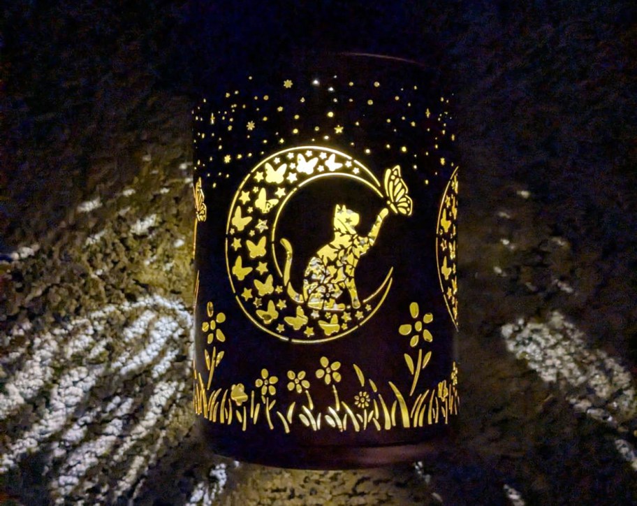 solar lantern with a cat design on a patio