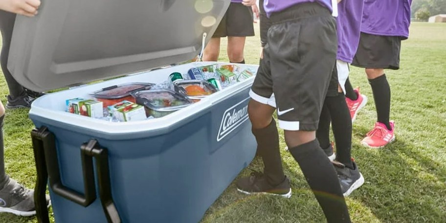 kids getting drinks out of coleman blue cooler 