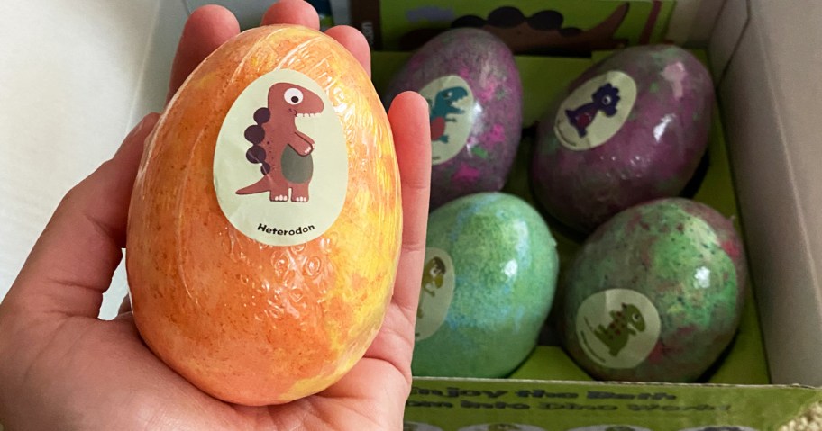 hand holding a dinosaur egg bath bomb