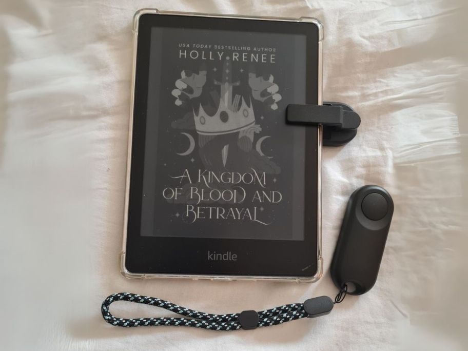 black E-Reader Remote Page Turner next to Kindle on blanket