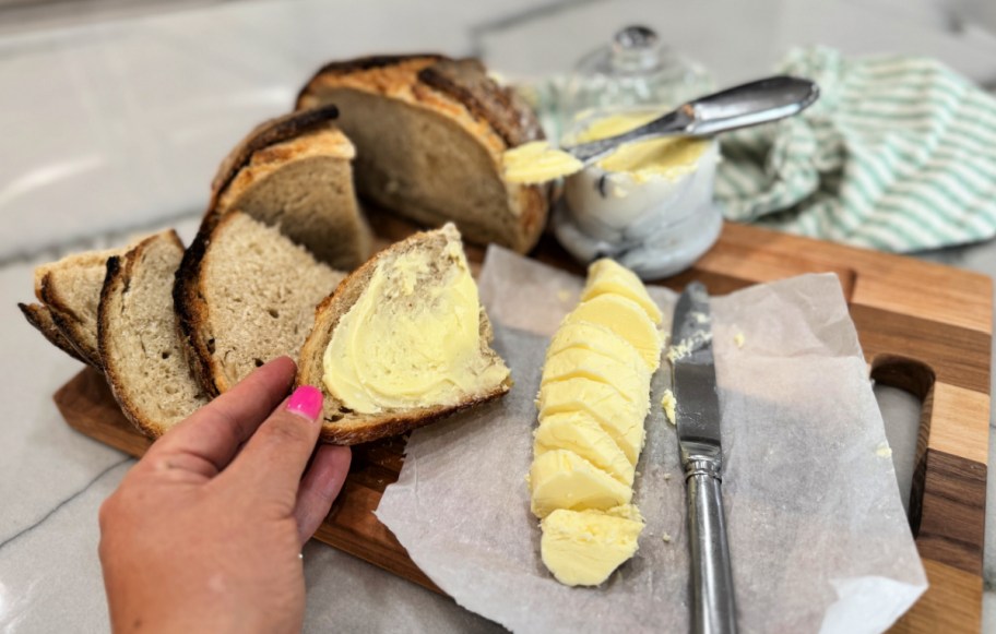 holding a slice of bread with homemade butter