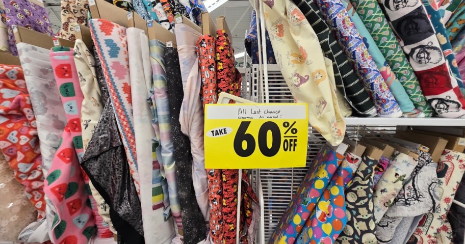 bolts of fabric on a store shelf with a sign that says 60% off