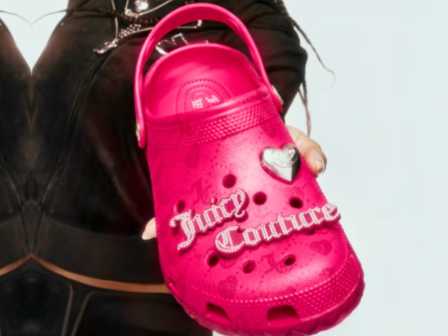 hand holding pink croc with juicy couture and jibbitz