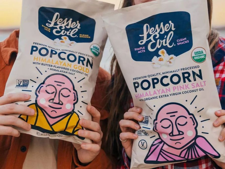 two people holding LesserEvil popcorn bags