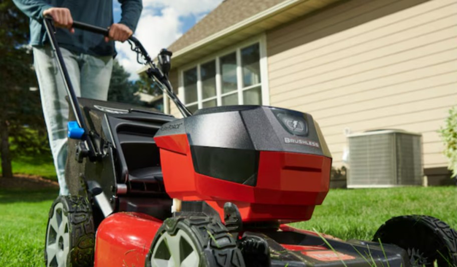 man pushing red lawn mower