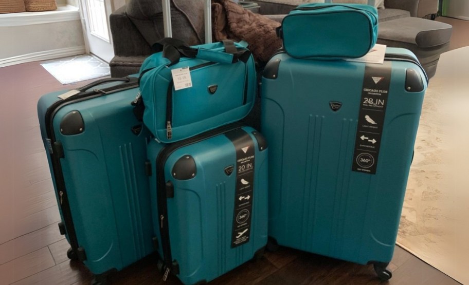 five piece spinner luggage set in teal in a livingroom