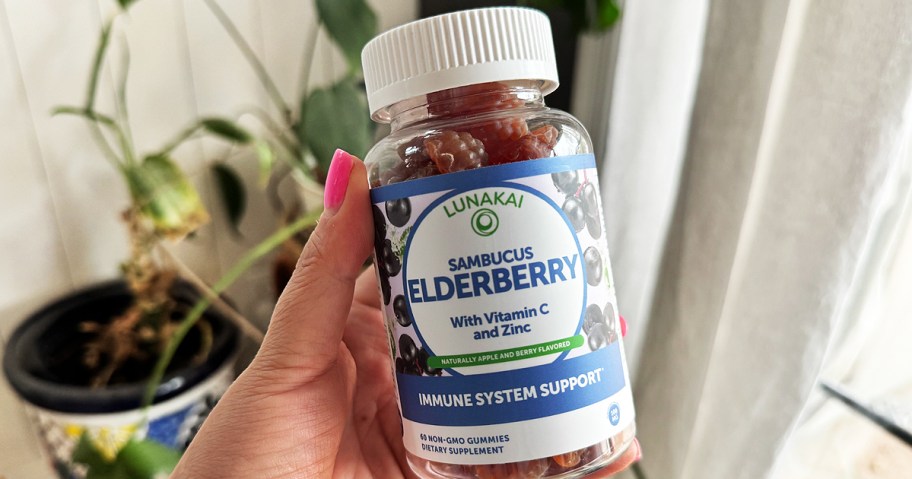 hand holding a bottle of elderberry gummies