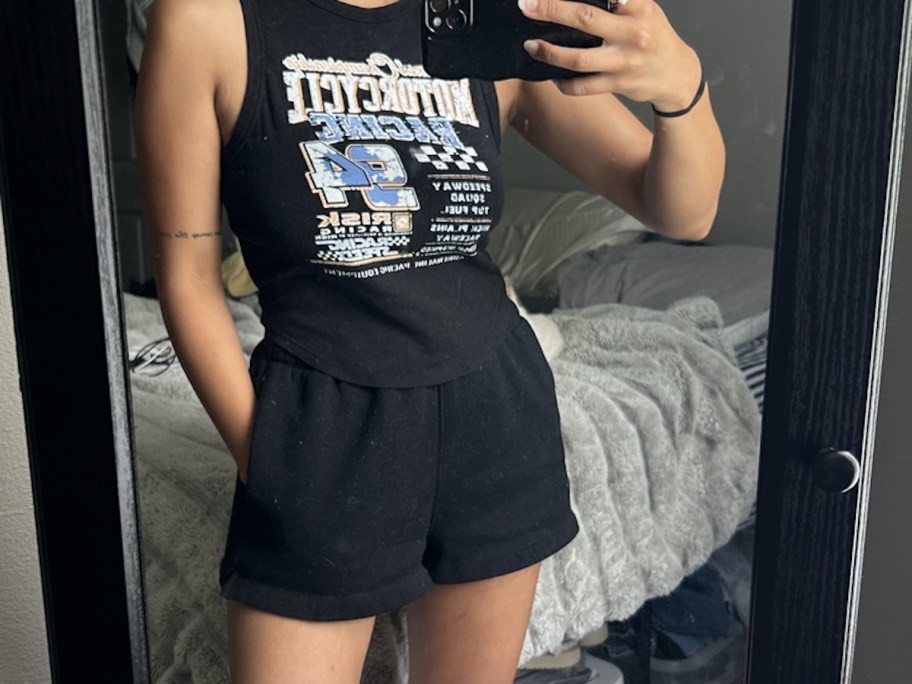 woman modeling muscle tank and shorts in mirror