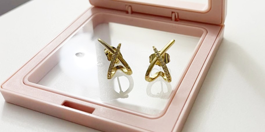 two x gold earrings in box on table